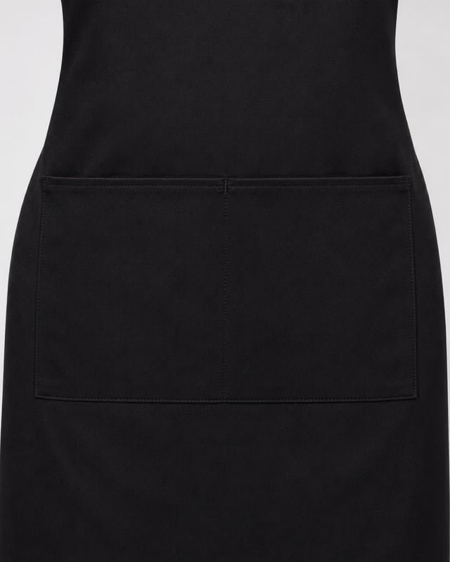 Apron front pocket with a central divider Reference illustration: Close-up of a black apron front pocket with stitched edges and a central dividing seam.