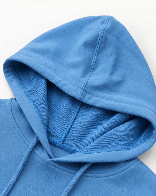 Blue hoodie opening and inside finish Reference illustration: Close-up of a blue hood opening showing the edge stitching, inside seams and drawcord.