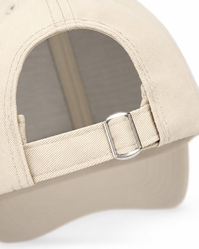 Cap back buckle and adjustment strap Reference illustration: Close-up of a beige cap with a metal rear buckle, fabric adjustment strap and curved back opening.