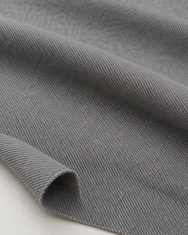 Reference illustration of grey fabric with diagonal twill lines and a turned-up edge.