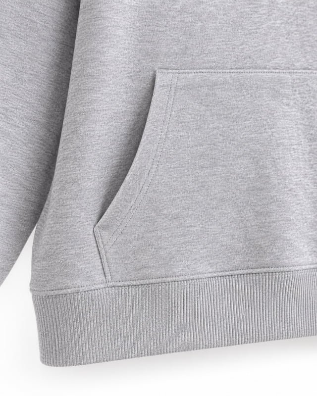 Hoodie pouch pocket and ribbed hem Reference illustration: Close-up of a grey sweatshirt pouch pocket with stitched openings above a ribbed lower hem.