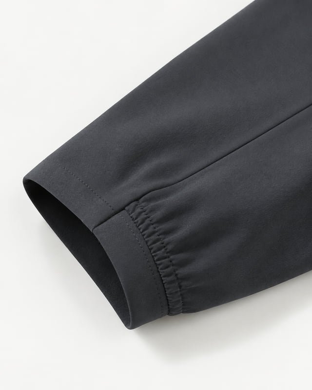 Reference illustration of a charcoal sleeve opening with a smooth cuff band and a gathered elastic section.
