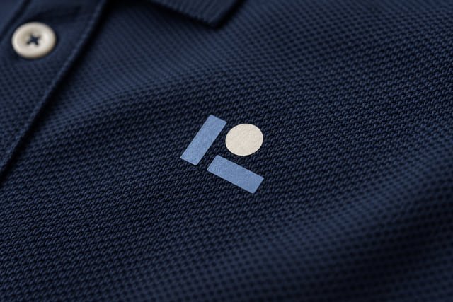Illustration of thin blue shapes and a cream circle heat-transferred onto navy knit fabric.