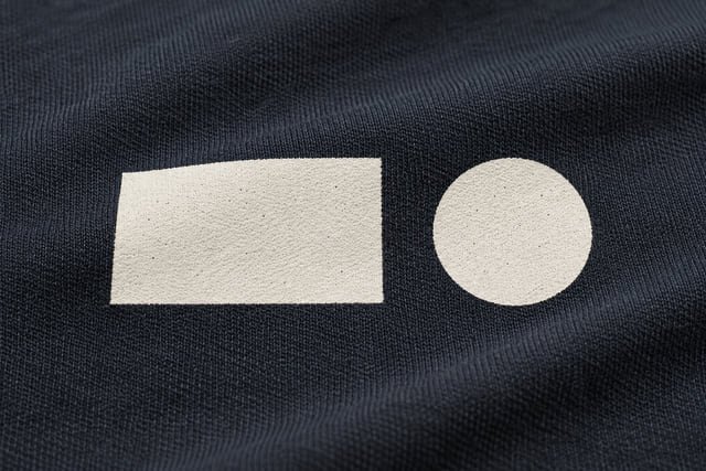 Illustration of a cream rectangle and circle printed directly onto dark knit fabric, with the surface texture visible.