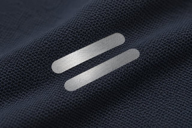 Illustration of two silver-grey reflective strips catching the light on dark knit fabric.