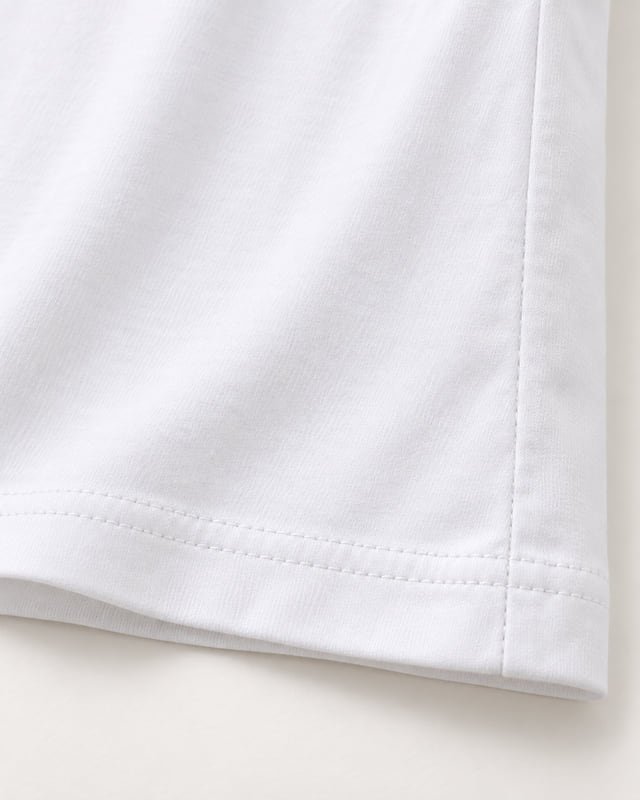 T-shirt side seam and double-stitched hem Reference illustration: Close-up of a white T-shirt side seam meeting a hem with two parallel rows of stitching.