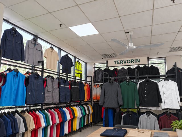 Tervorin workwear showroom visualization Edited showroom view with TERVORIN signage, work shirts, polos, jackets and vests displayed on clothing rails.